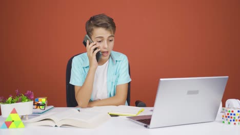 Niño-Usando-Una-Computadora-Portátil-Hablando-Nerviosamente-Por-Teléfono.